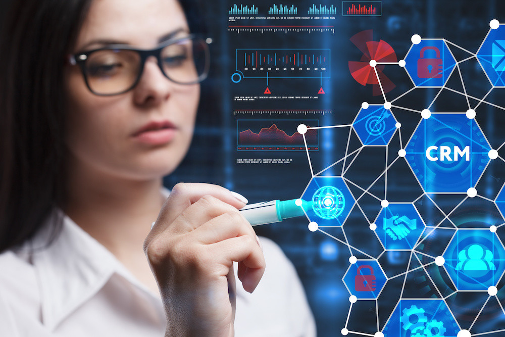 The concept of business, technology, the Internet and the network. A young entrepreneur working on a virtual screen of the future and sees the inscription: CRM