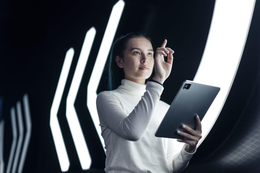 Manažerka s tabletem představuje moderní firemní řízení inspirované umělou inteligencí a principy vibe managementu pro adaptabilní organizace.