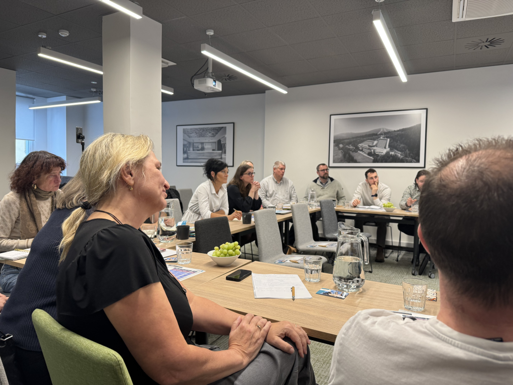 Účastníci Experience Hub Meetupu sledují prezentaci o adaptabilitě a umělé inteligenci, diskutují nad příklady z firemní praxe.